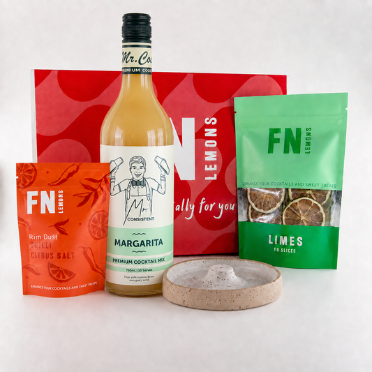 A curated cocktail mix and garnish gift set featuring a bottle of Consistent Margarita mix, a red bag of F.N Lemon Rim Dust, a green bag of F.
