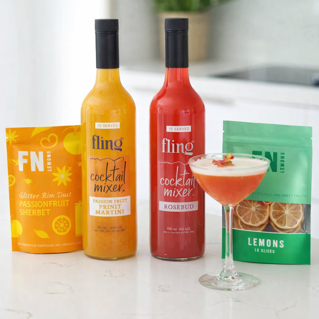 Two bottles of Fling cocktail mixer with a glass of cocktail and packaging on a countertop.