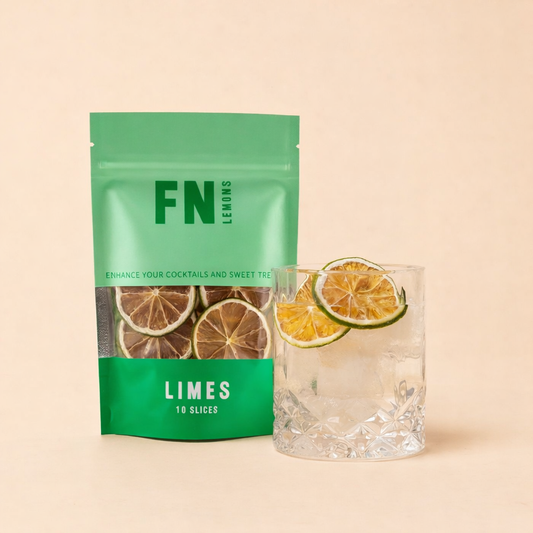 Green package of dried limes next to a glass with lime slices on a beige background