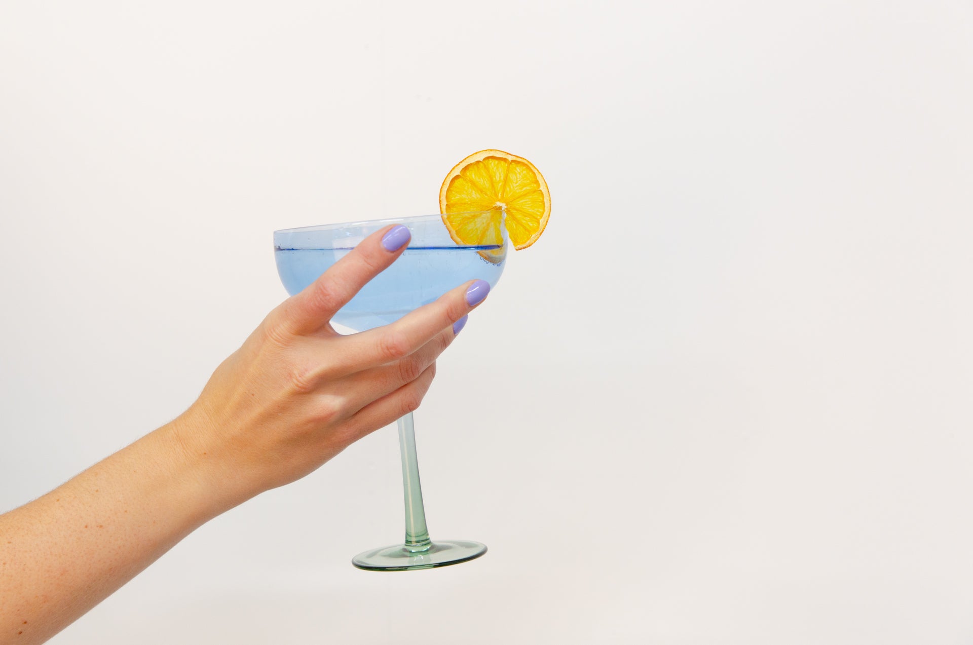 F N Lemons blue cocktail glass with dried orange garnish
