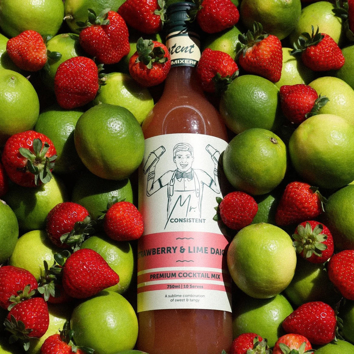 Bottle of 'Consistent' Strawberry & Lime Daiquiri mix surrounded by strawberries and limes.